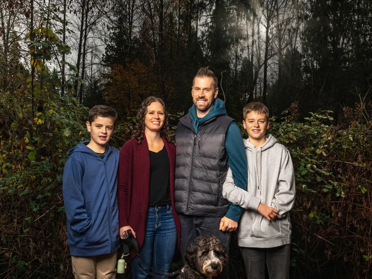 Family standing together outdoors with their dog