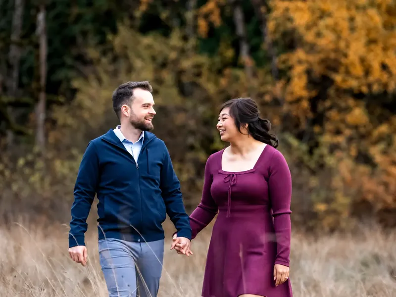 Couple walking hand in hand through a field
