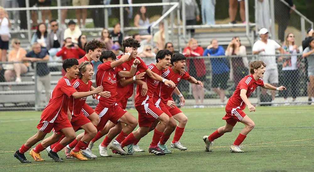 Soccer team rushing onto the field in celebration