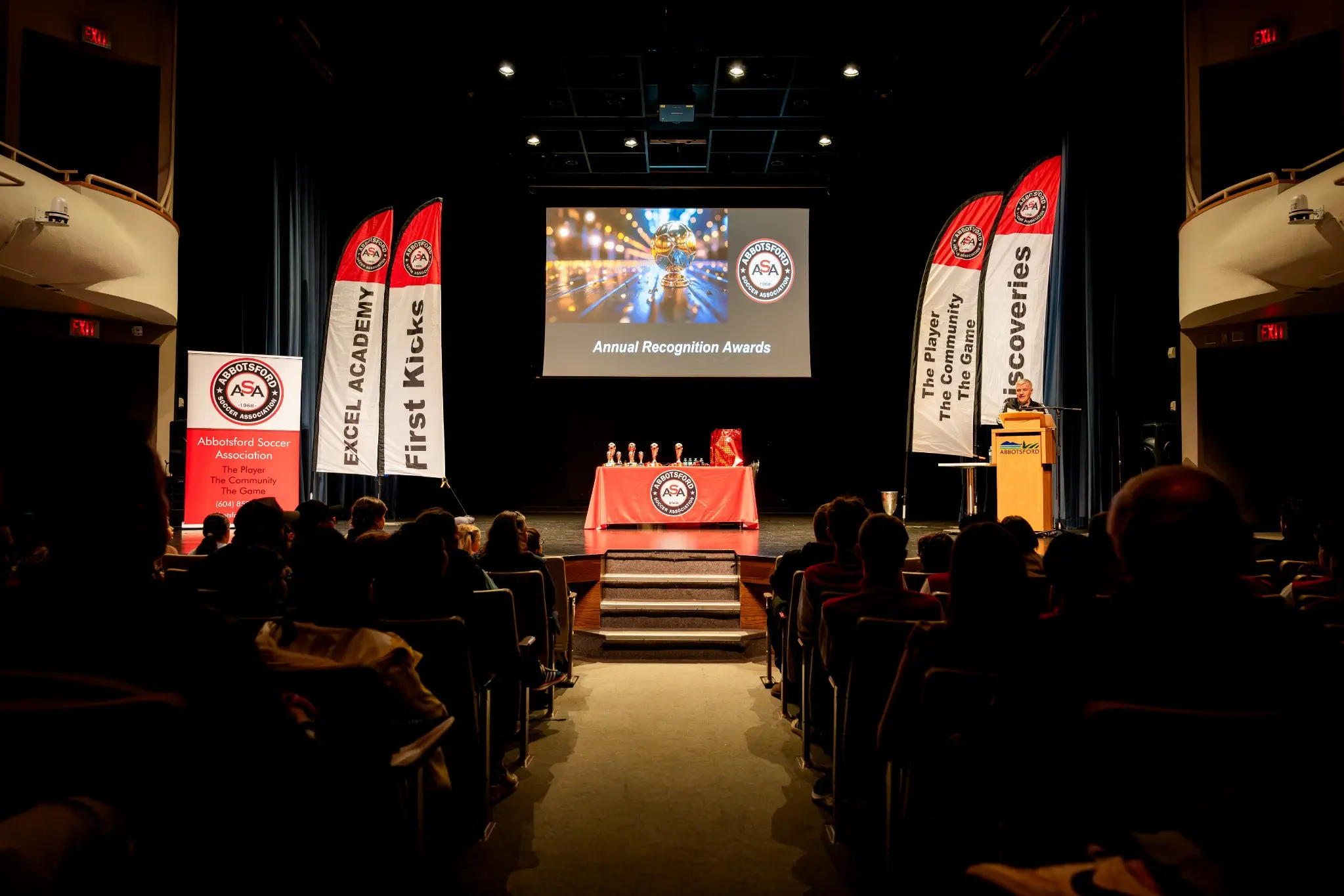 Audience watching an awards ceremony presentation in a theatre