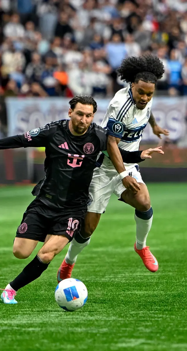 Professional soccer players competing for the ball during a match