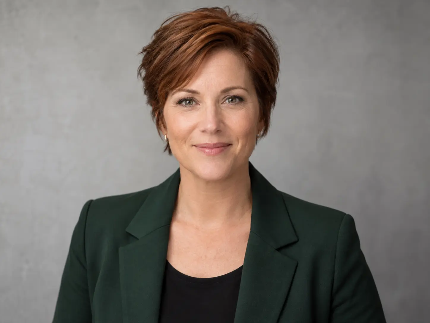 Professional corporate headshot of a woman in a green blazer