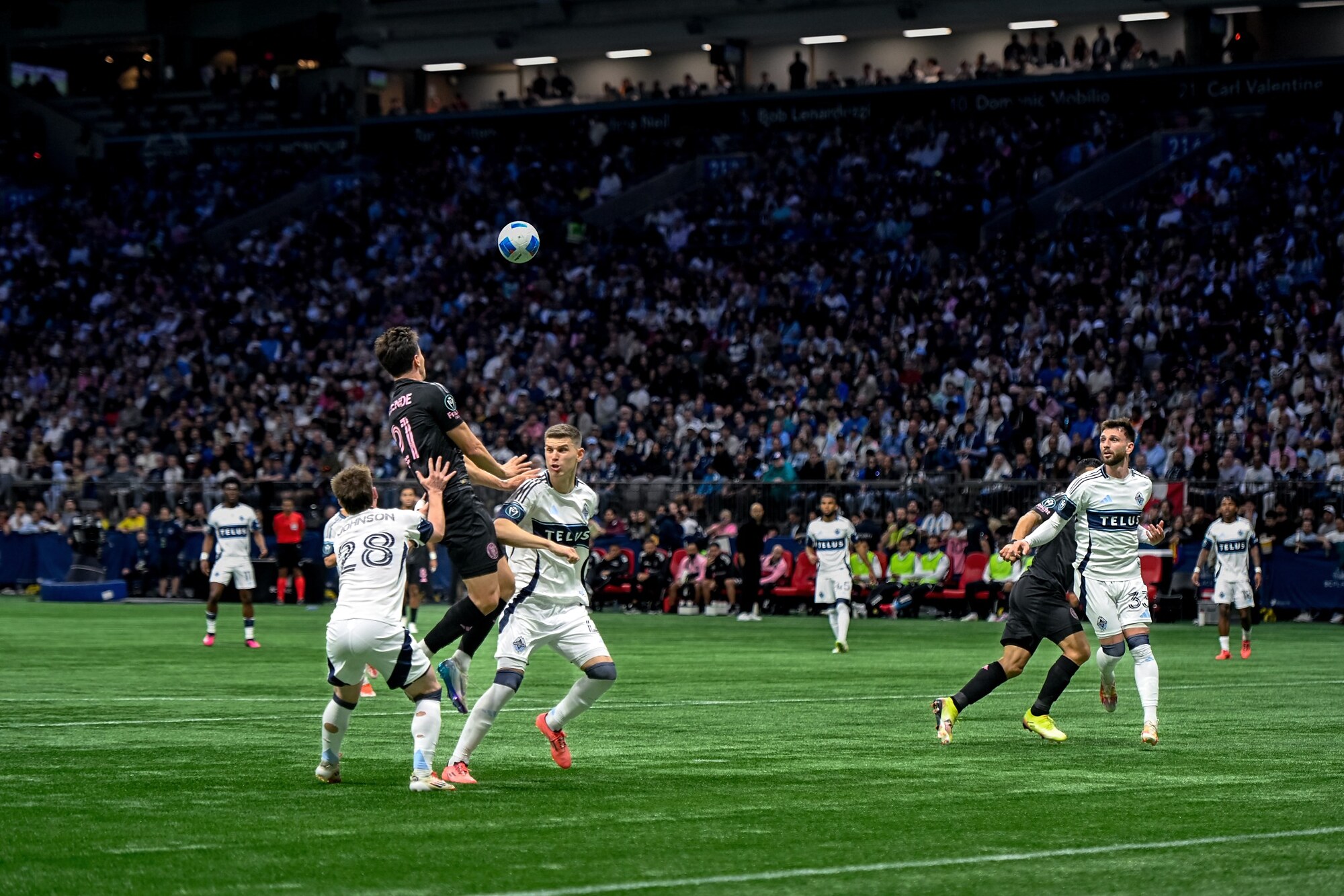 Soccer players contesting the ball during a professional match