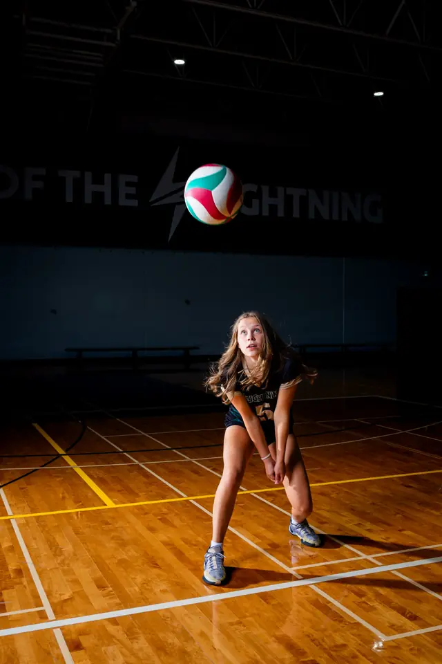Volleyball athlete preparing to receive the ball on an indoor court